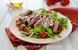 Taglia di Scottona con rucola, scaglie e pomodorini